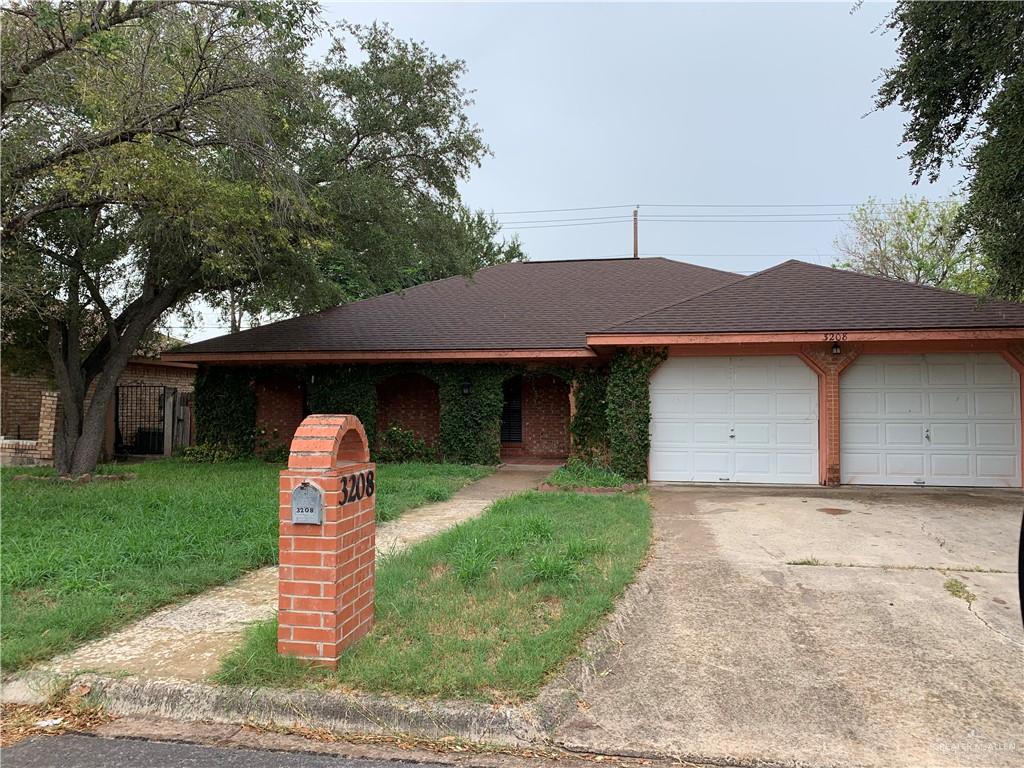 Ranch-style house featuring a front yard and a garage