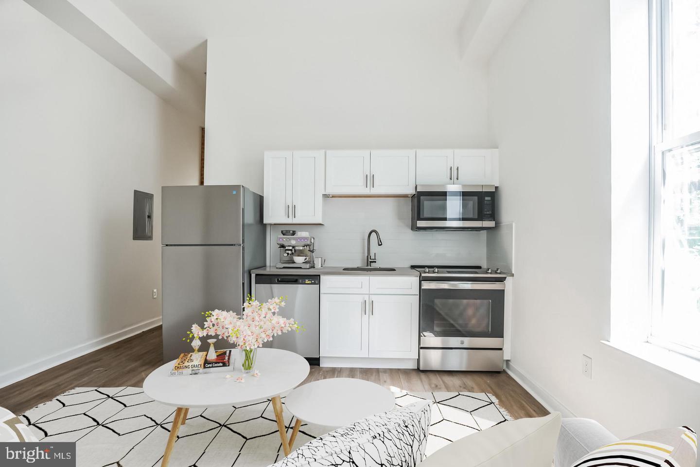 a kitchen with stainless steel appliances kitchen island granite countertop a refrigerator a stove a sink dishwasher with a dining table and chairs