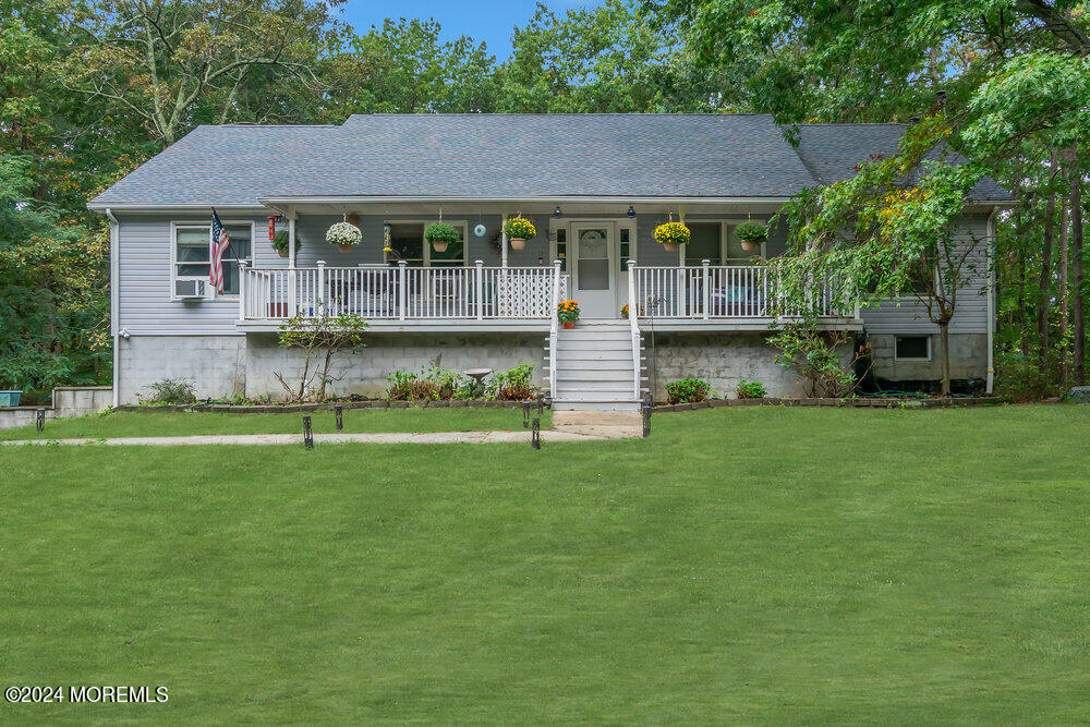 a view of a house with a yard deck and a large tree