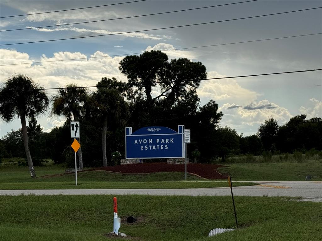 a sign board with a play ground in the back