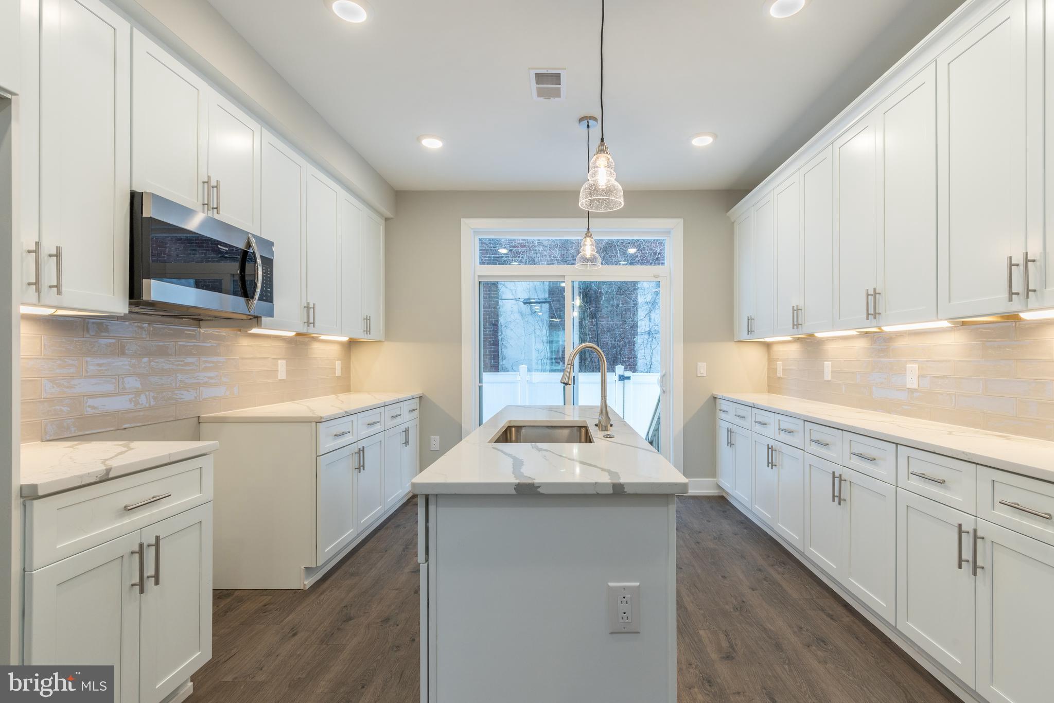 a large kitchen with stainless steel appliances kitchen island granite countertop a sink and cabinets