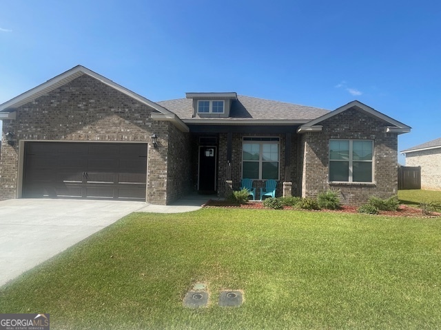 a front view of a house with a garden and yard