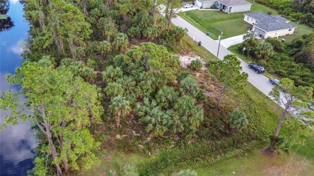 an aerial view of residential house with outdoor space and trees all around