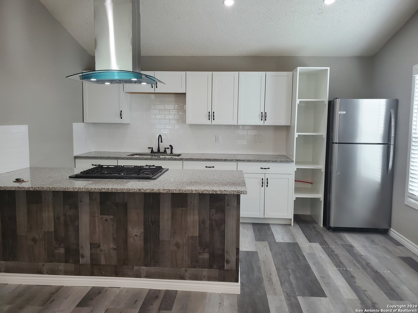 a kitchen with a refrigerator and a stove