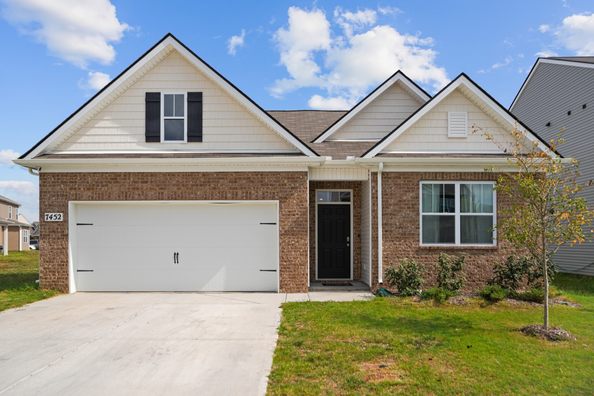 a front view of a house with a yard and garage