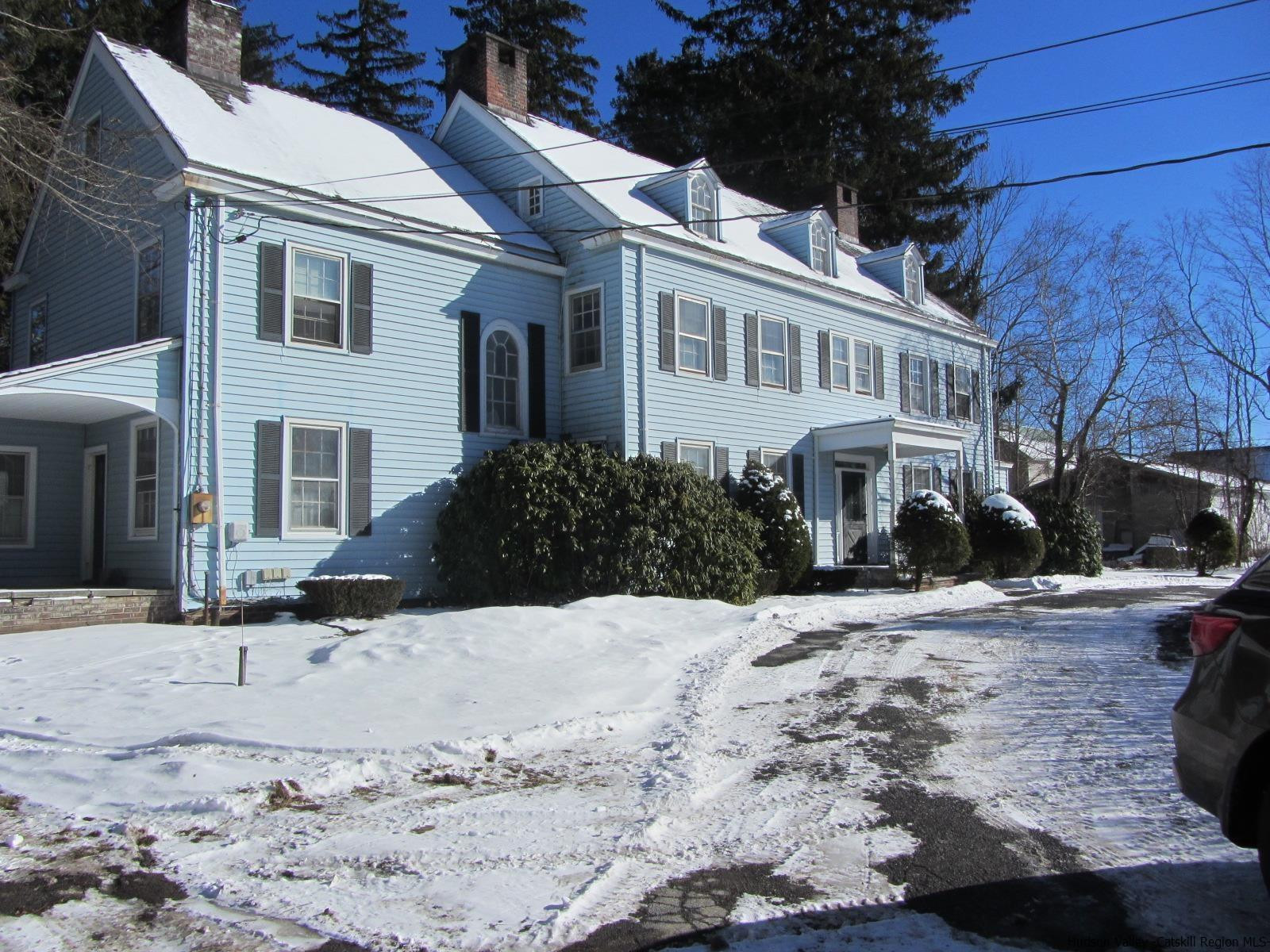 a view of a white house with a yard covered in snow