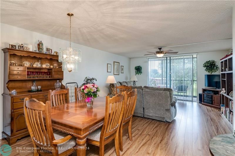 a view of a dining room with furniture a chandelier and wooden floor