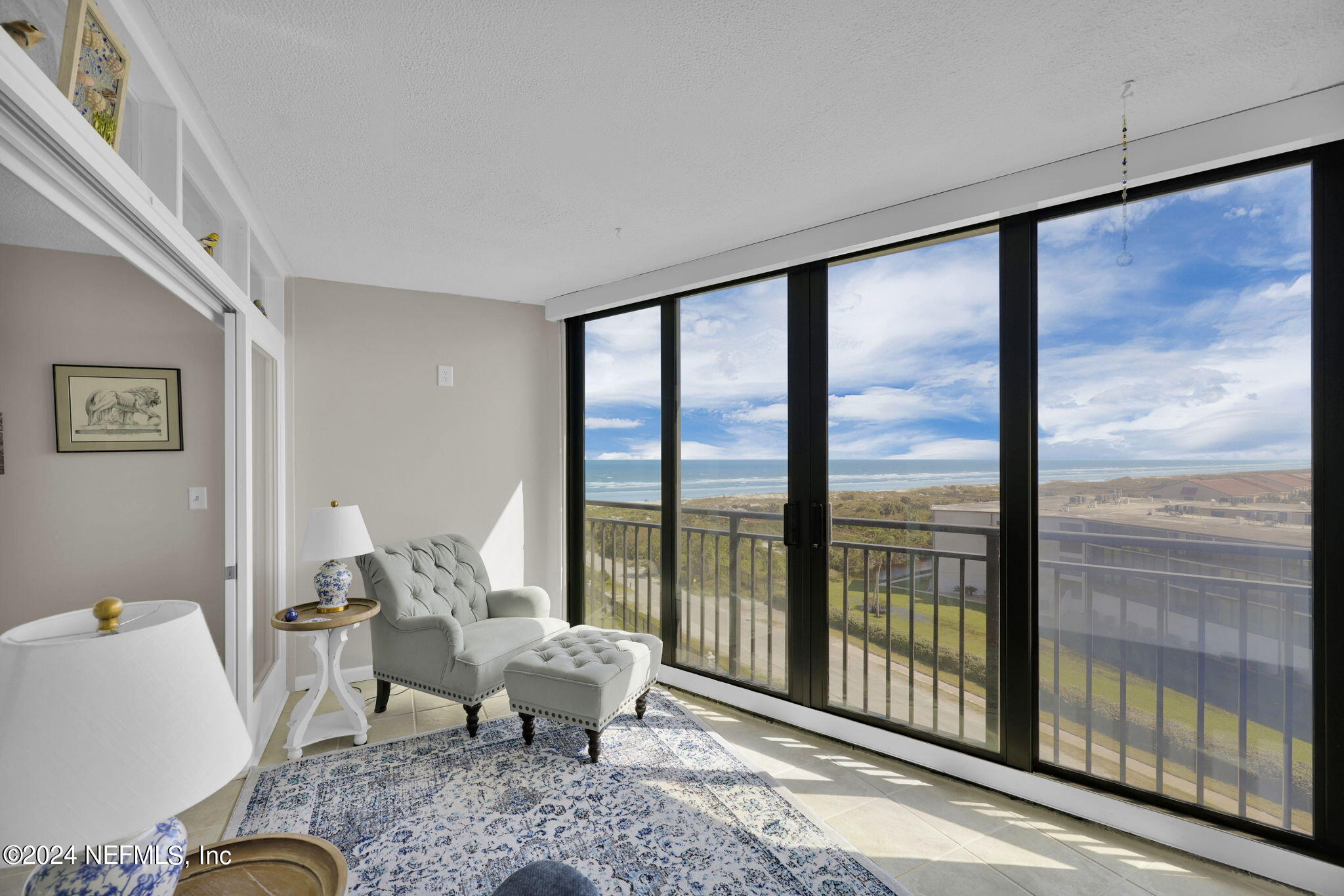 a living room with furniture and a floor to ceiling window