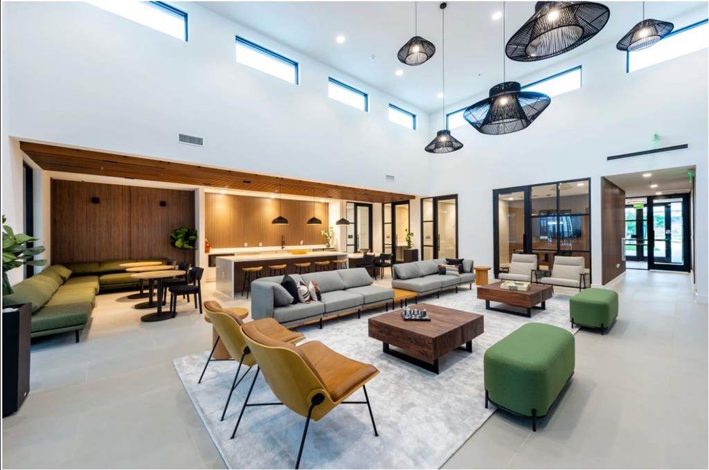 a living room with furniture kitchen view and a large window