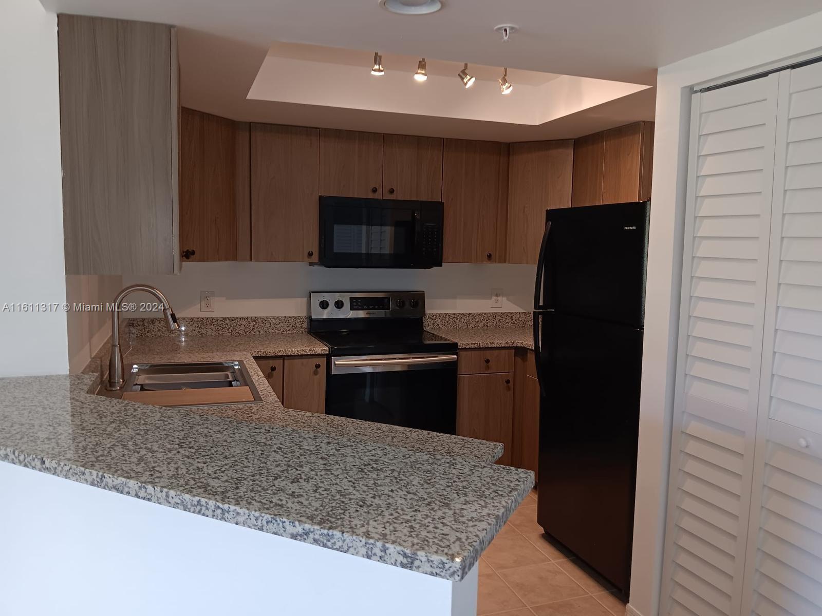 a kitchen with stainless steel appliances granite countertop a refrigerator and a sink