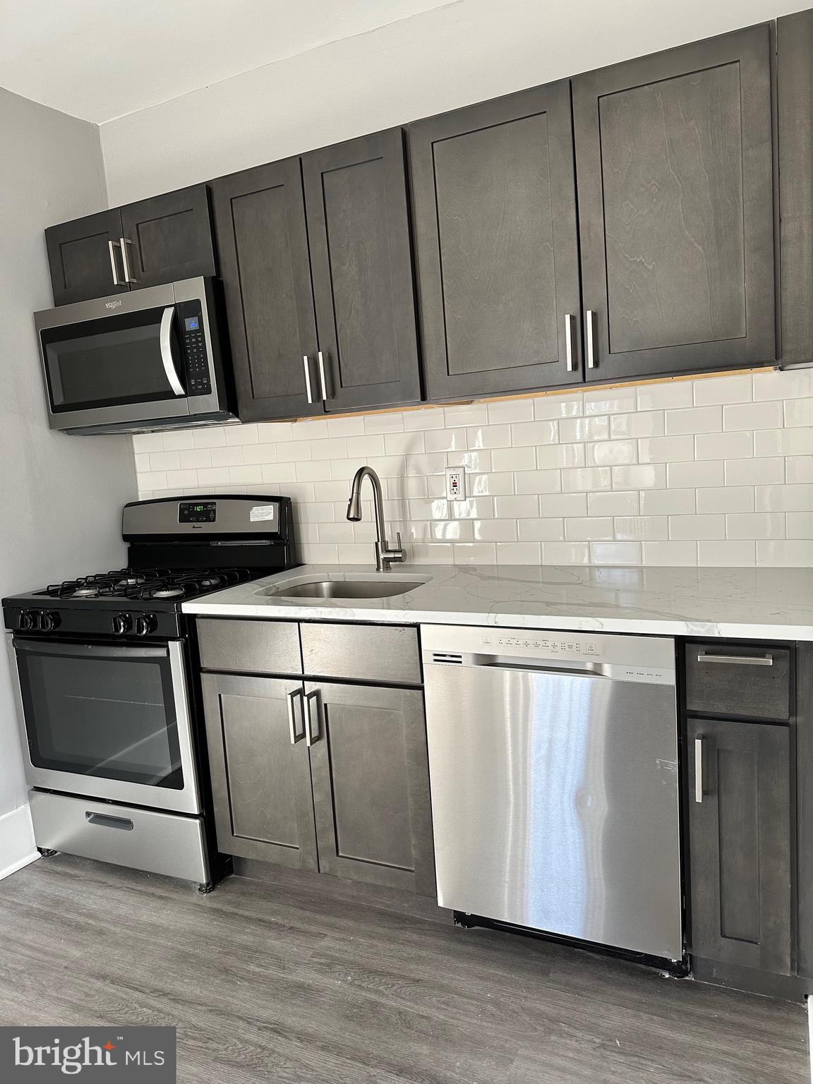 a kitchen with a sink a stove and cabinets