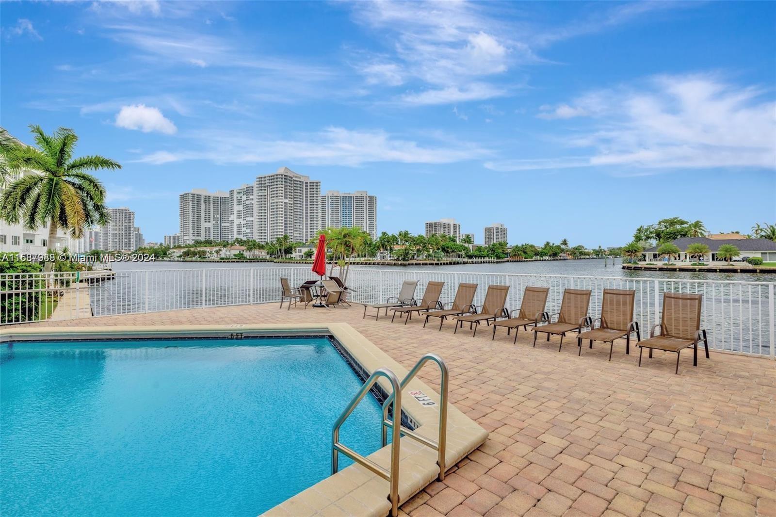 a view of a swimming pool with outdoor seating and city view