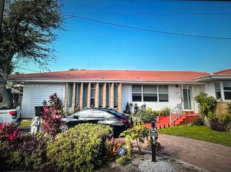 a front view of a house with a yard and a garden