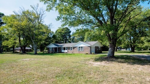 a view of a house with yard and sitting area