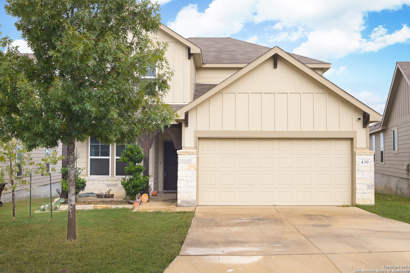 a view of backyard of house with outdoor seating and trees