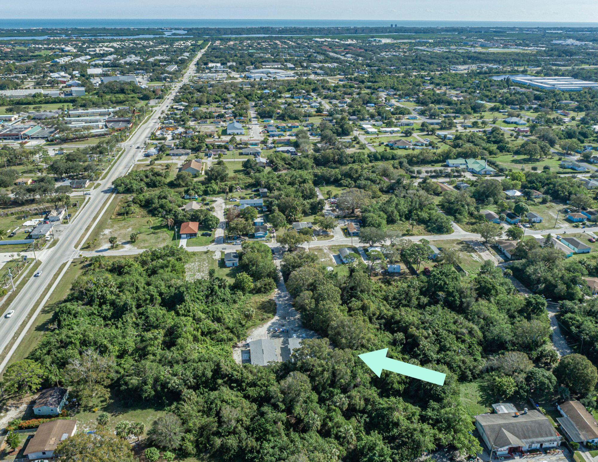 an aerial view of residential houses with outdoor space and trees