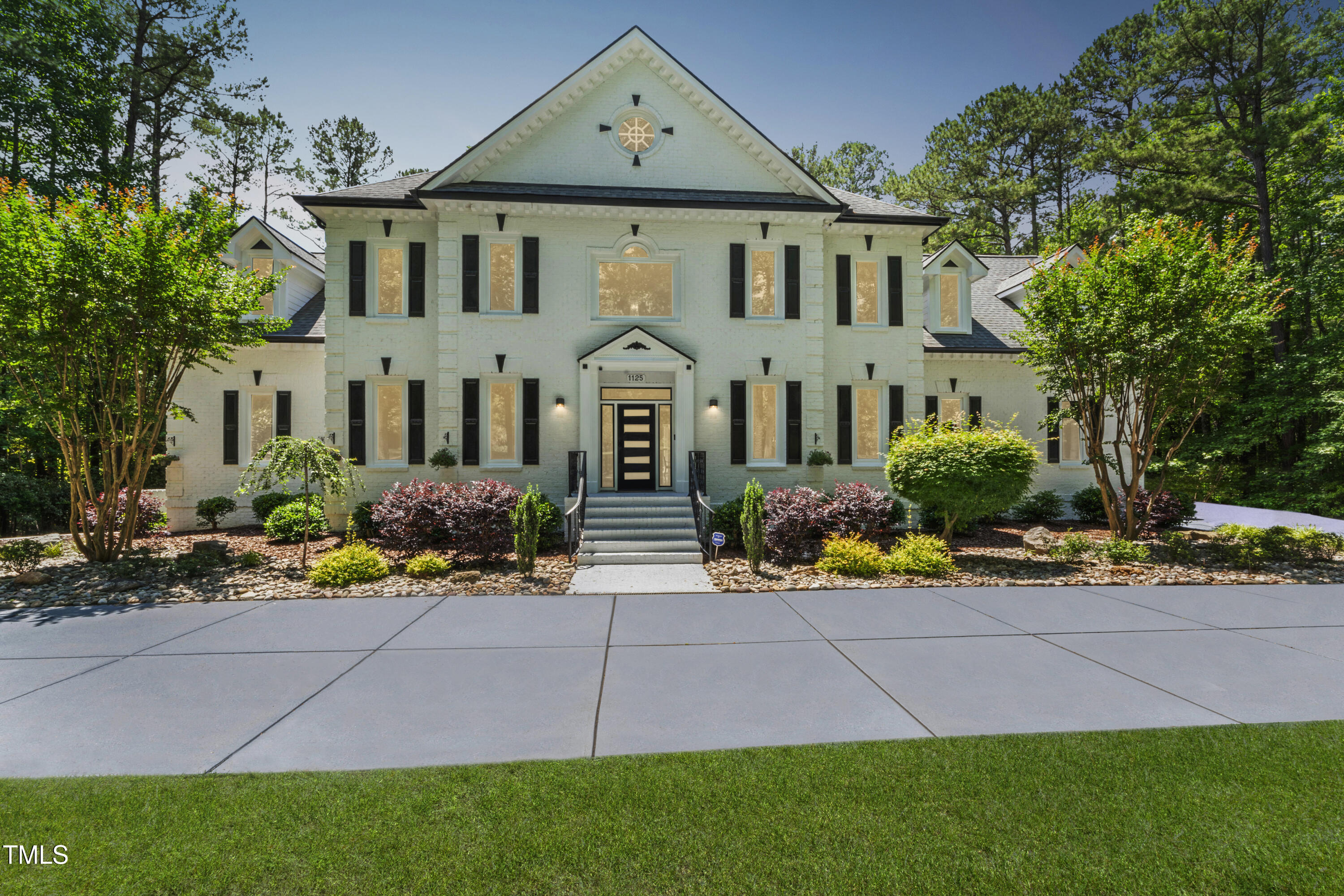 a front view of a house with a yard and potted plants