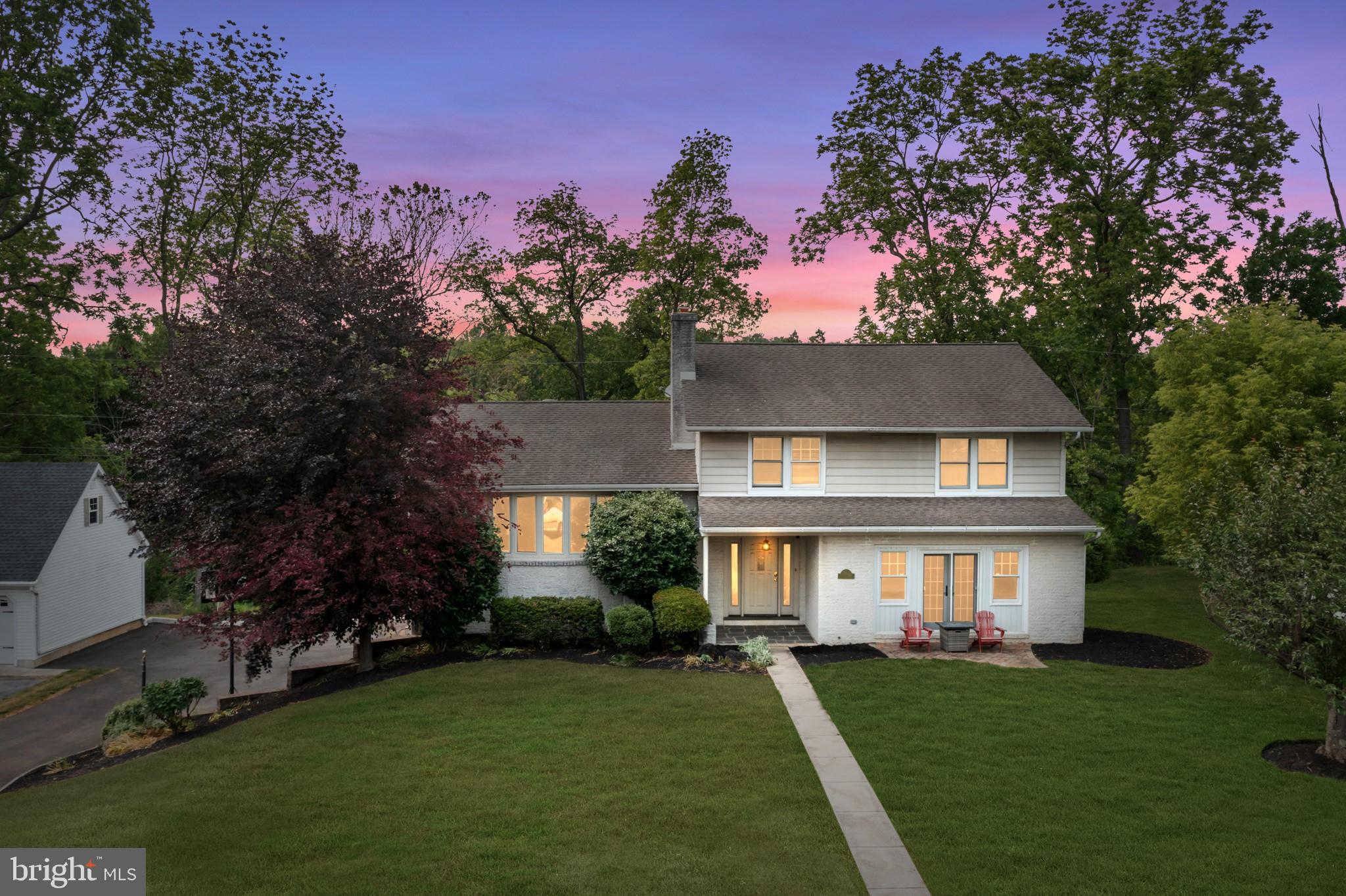 a front view of a house with a yard and trees