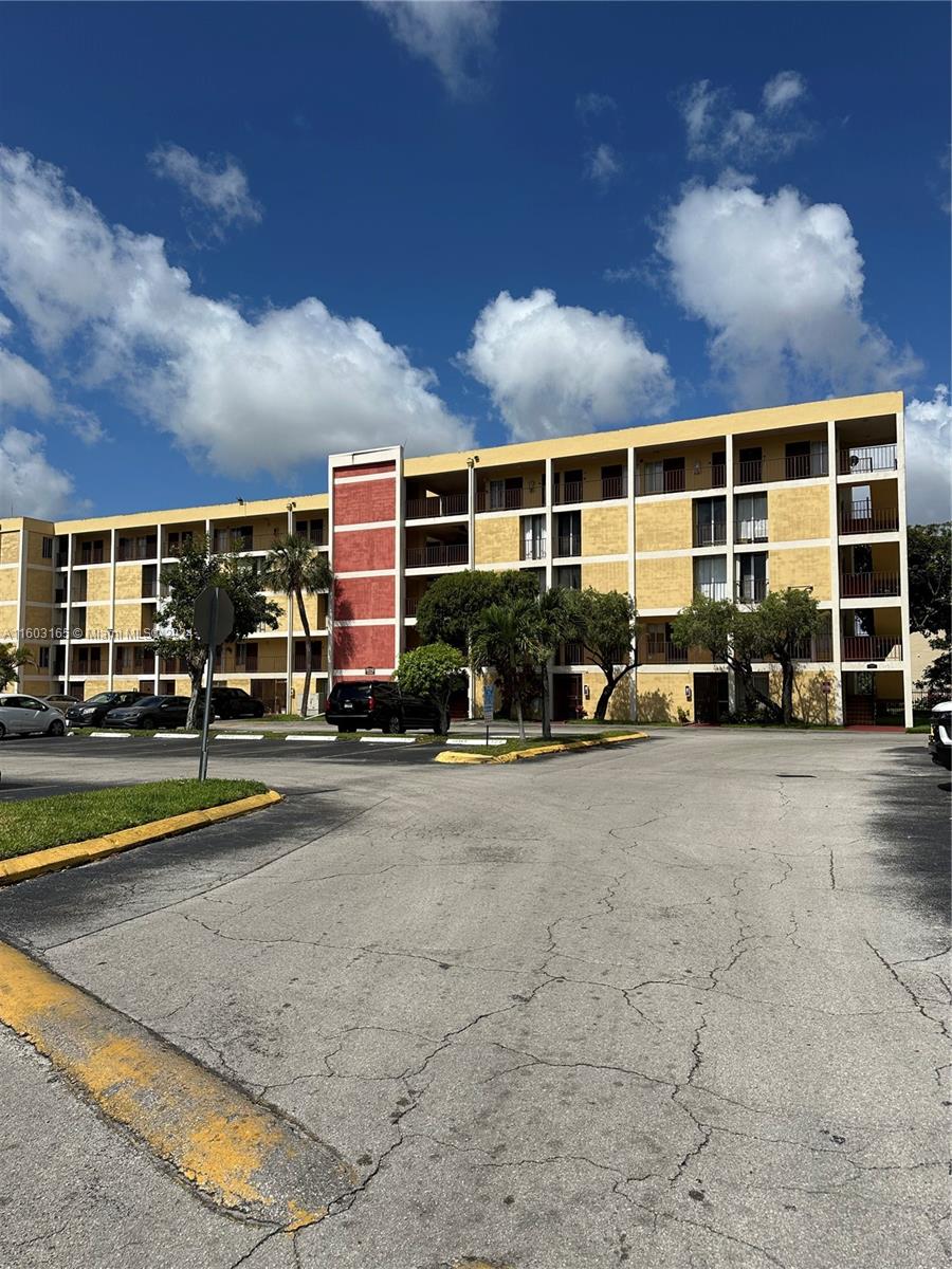 a front view of building with cars parked