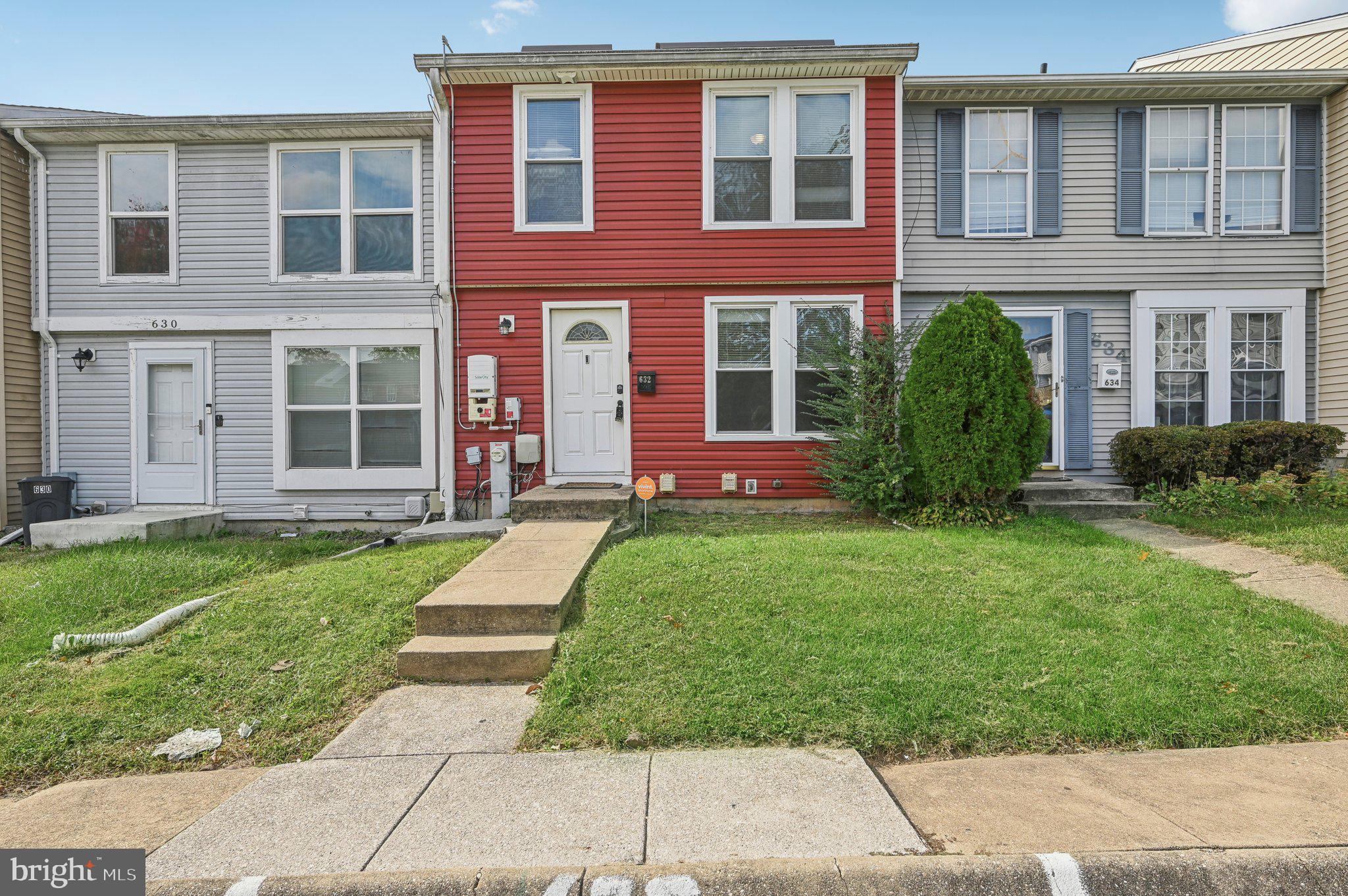 front view of a brick house with a yard