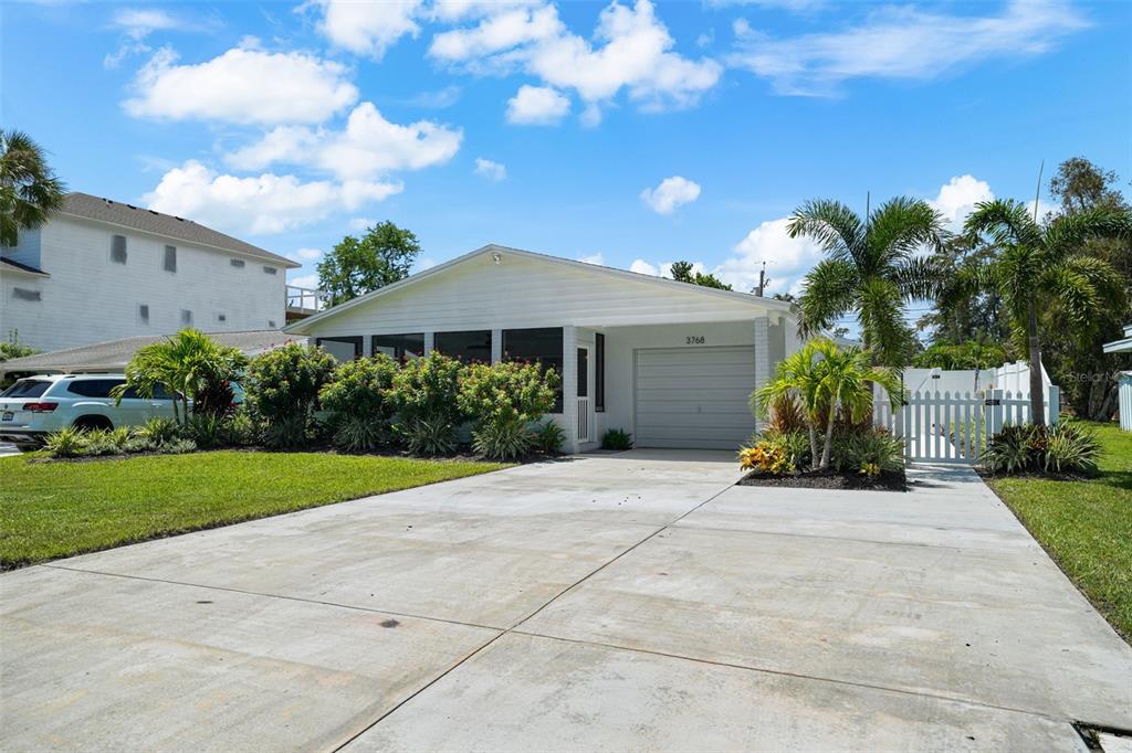 a view of a house with palm trees and a yard