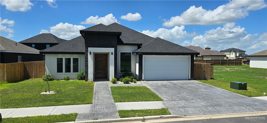 a front view of a house with yard and green space