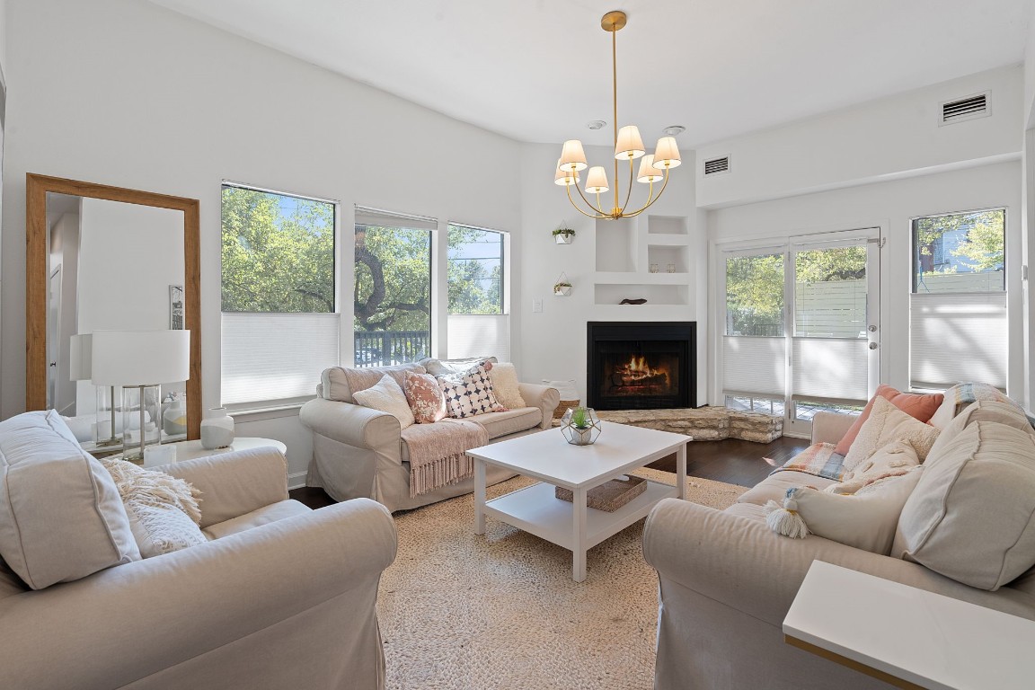 a living room with furniture a fireplace and a chandelier