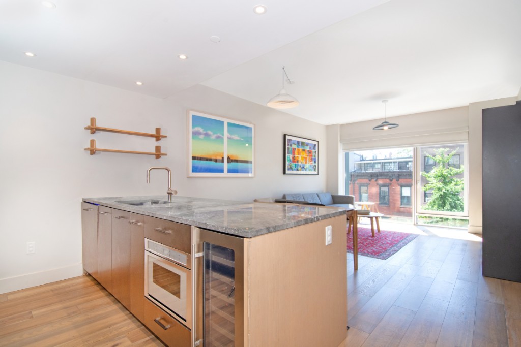 a kitchen with stainless steel appliances granite countertop wooden floors and white cabinets