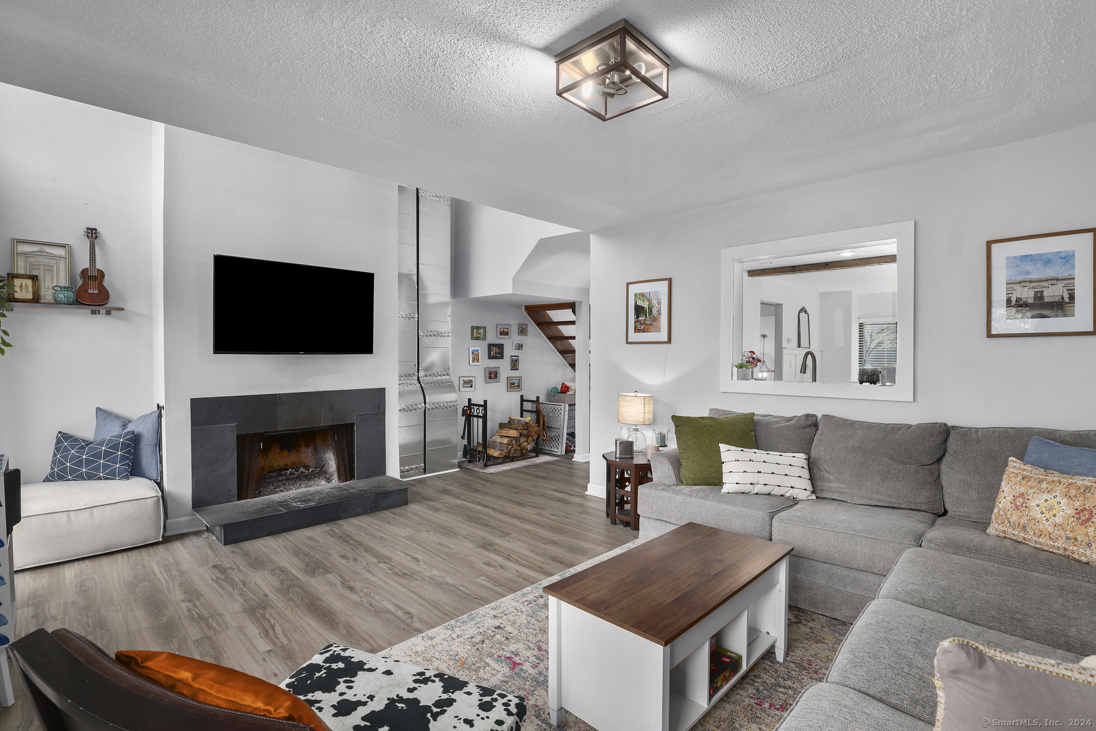 a living room with furniture a flat screen tv and a fireplace