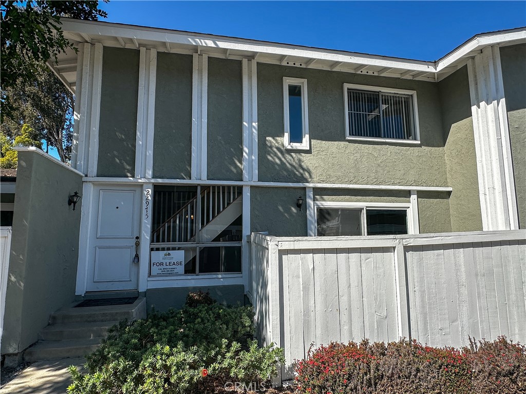 a view of a house with a window and wooden fence