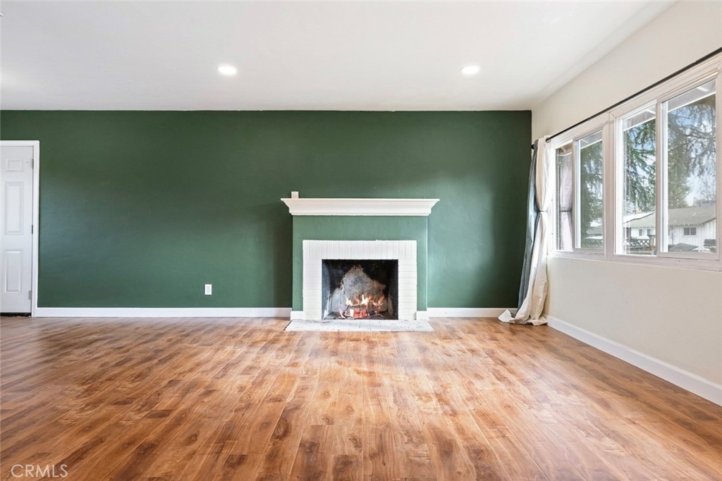 a view of an empty room with a fireplace and a window