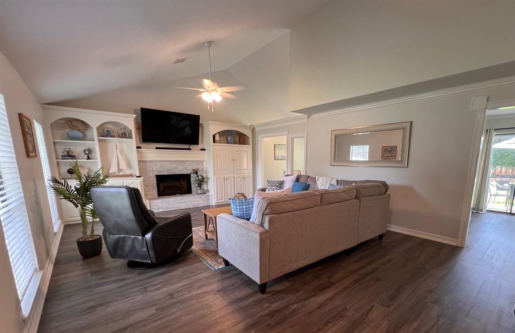 a living room with furniture a flat screen tv and a fireplace