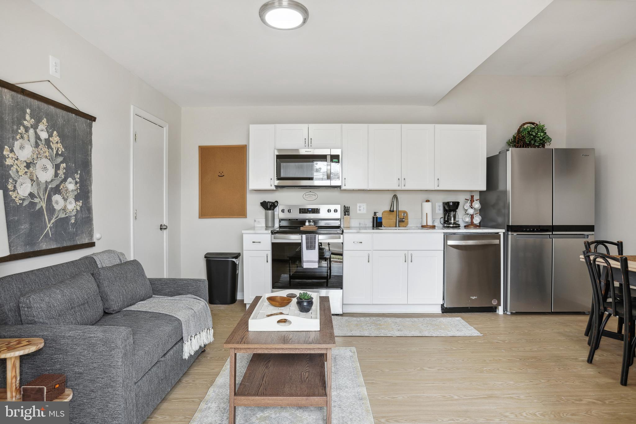 a living room with furniture a refrigerator and a table