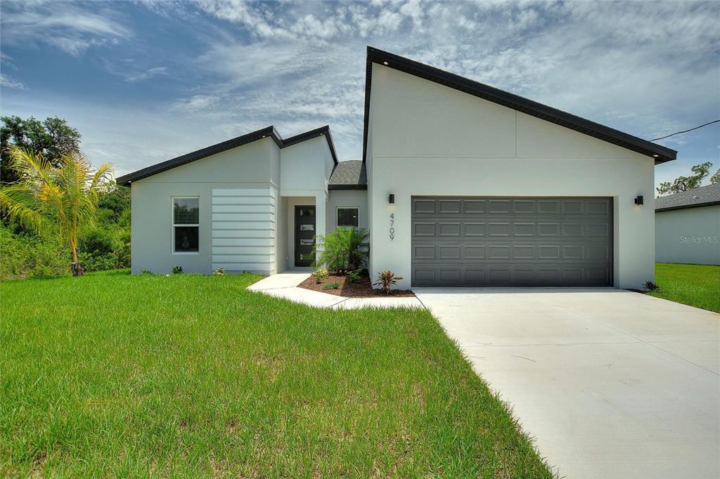 a front view of house with yard and garage