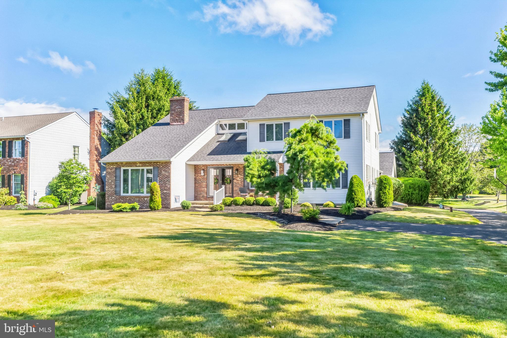 a front view of a house with a big yard and potted plants