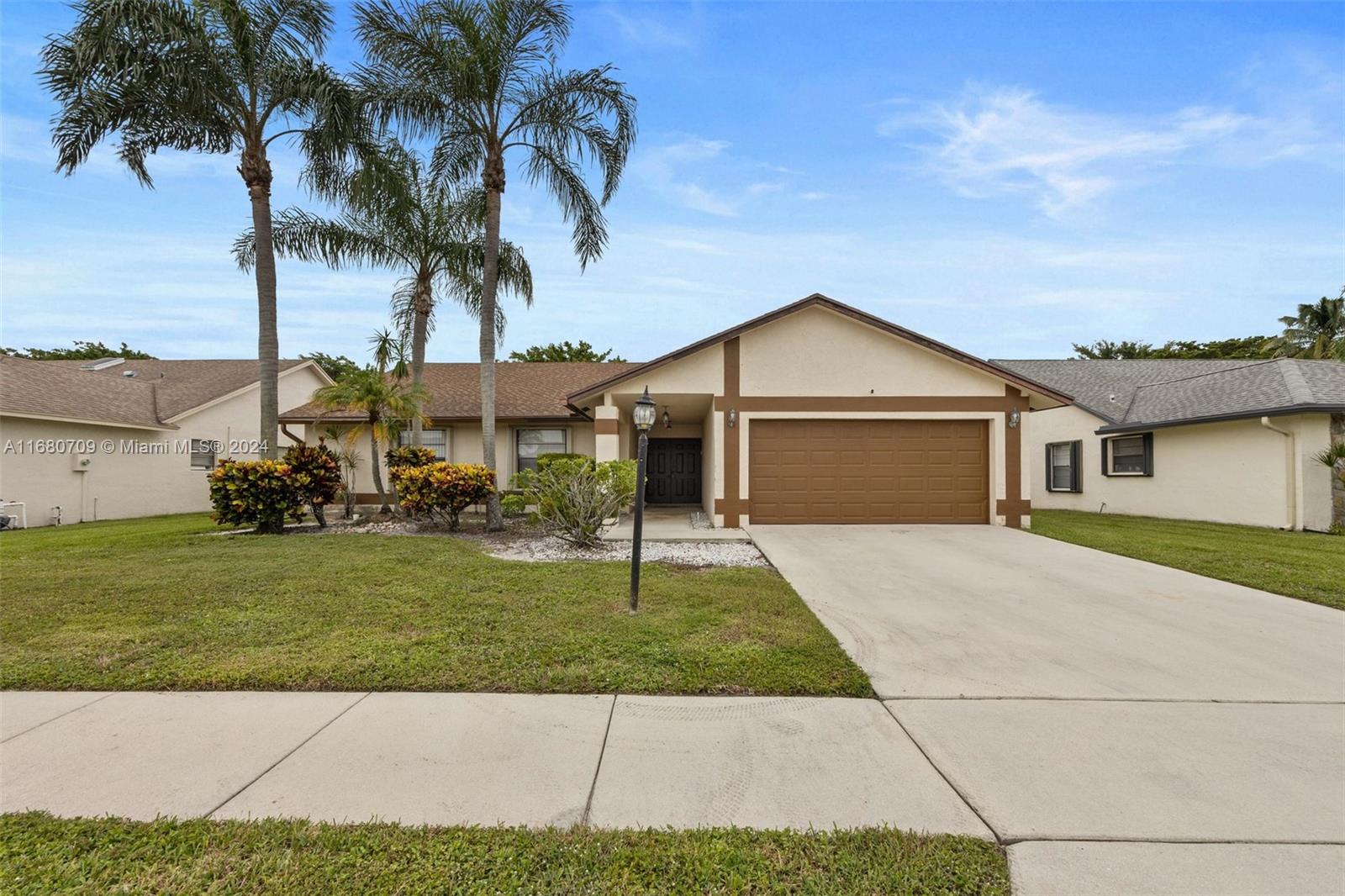 a front view of a house with a garden and yard