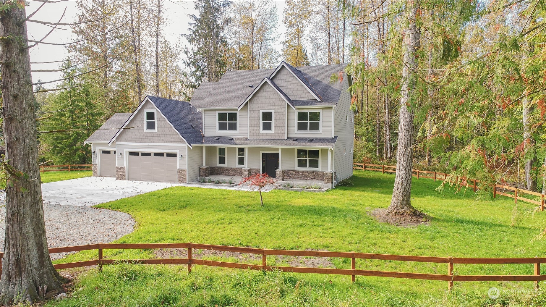 a view of house with a big yard and large trees