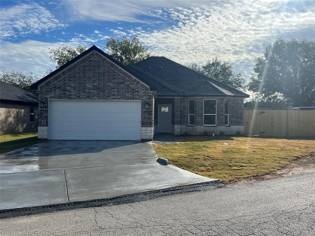 View of front of property with a garage and a front lawn