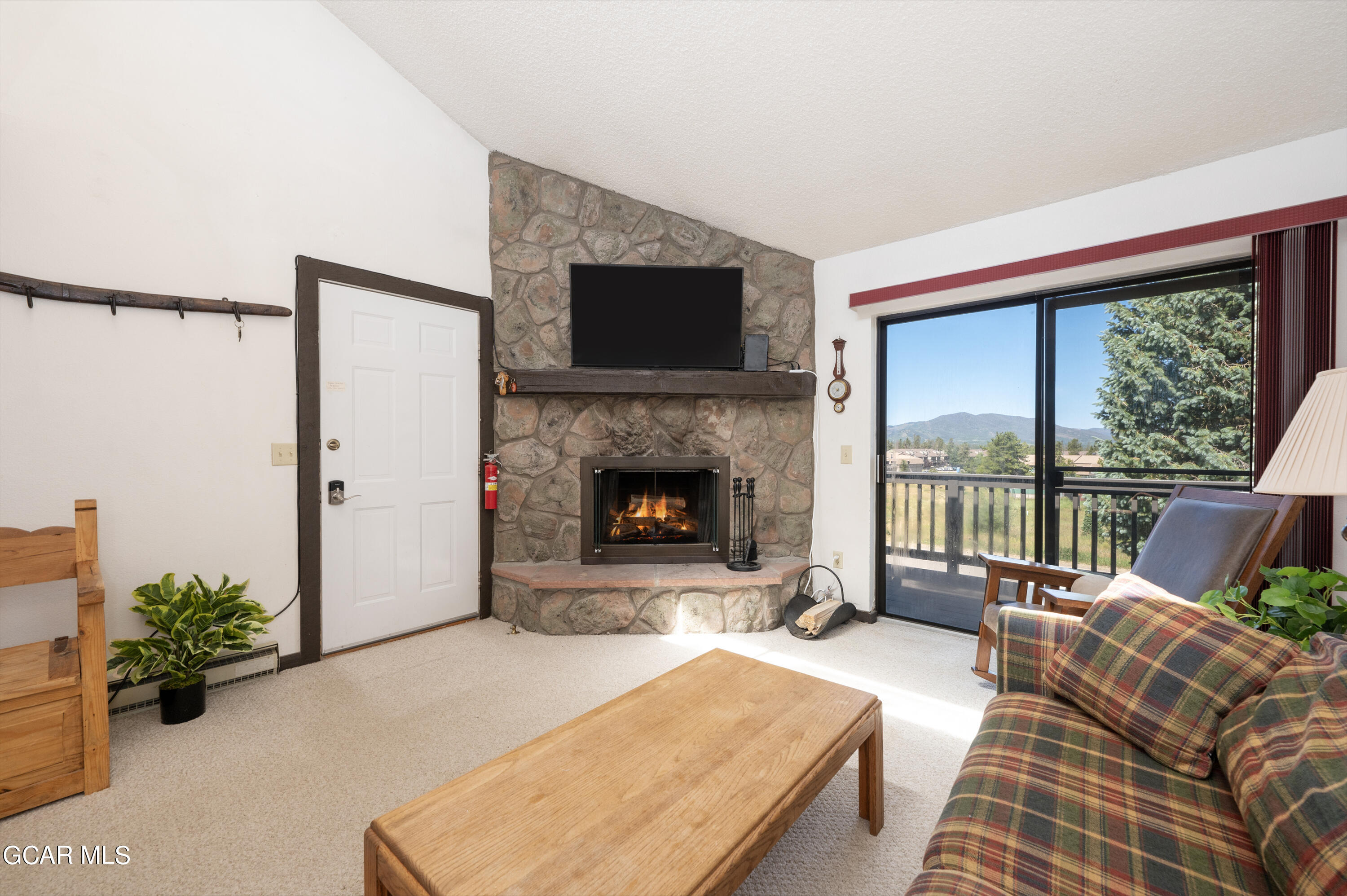 a living room with furniture large windows and a fireplace