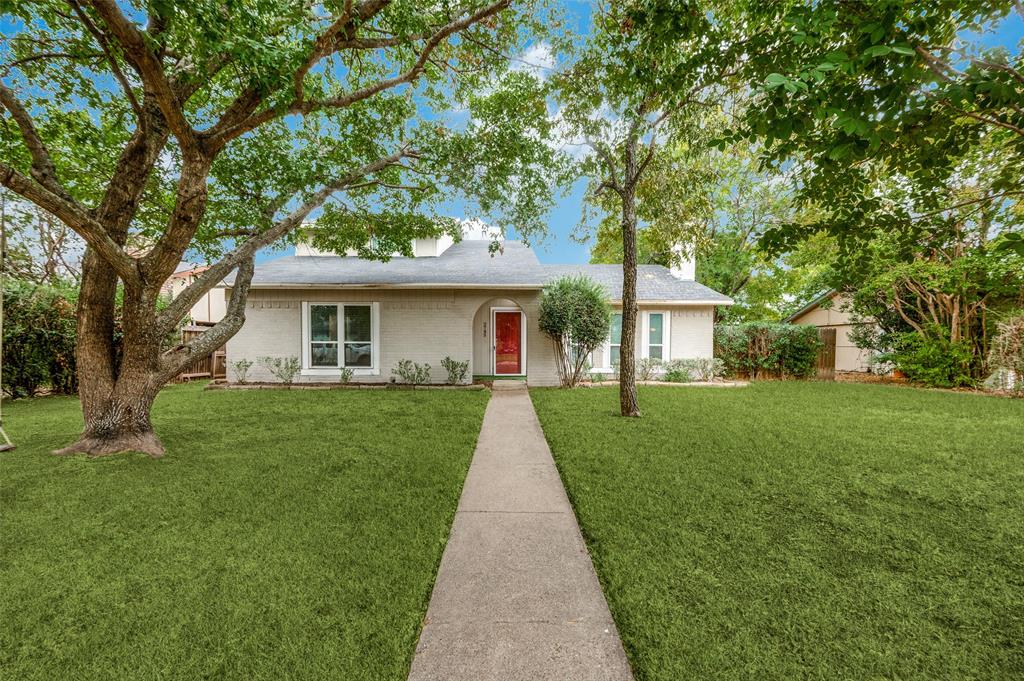 a front view of a house with a yard and trees