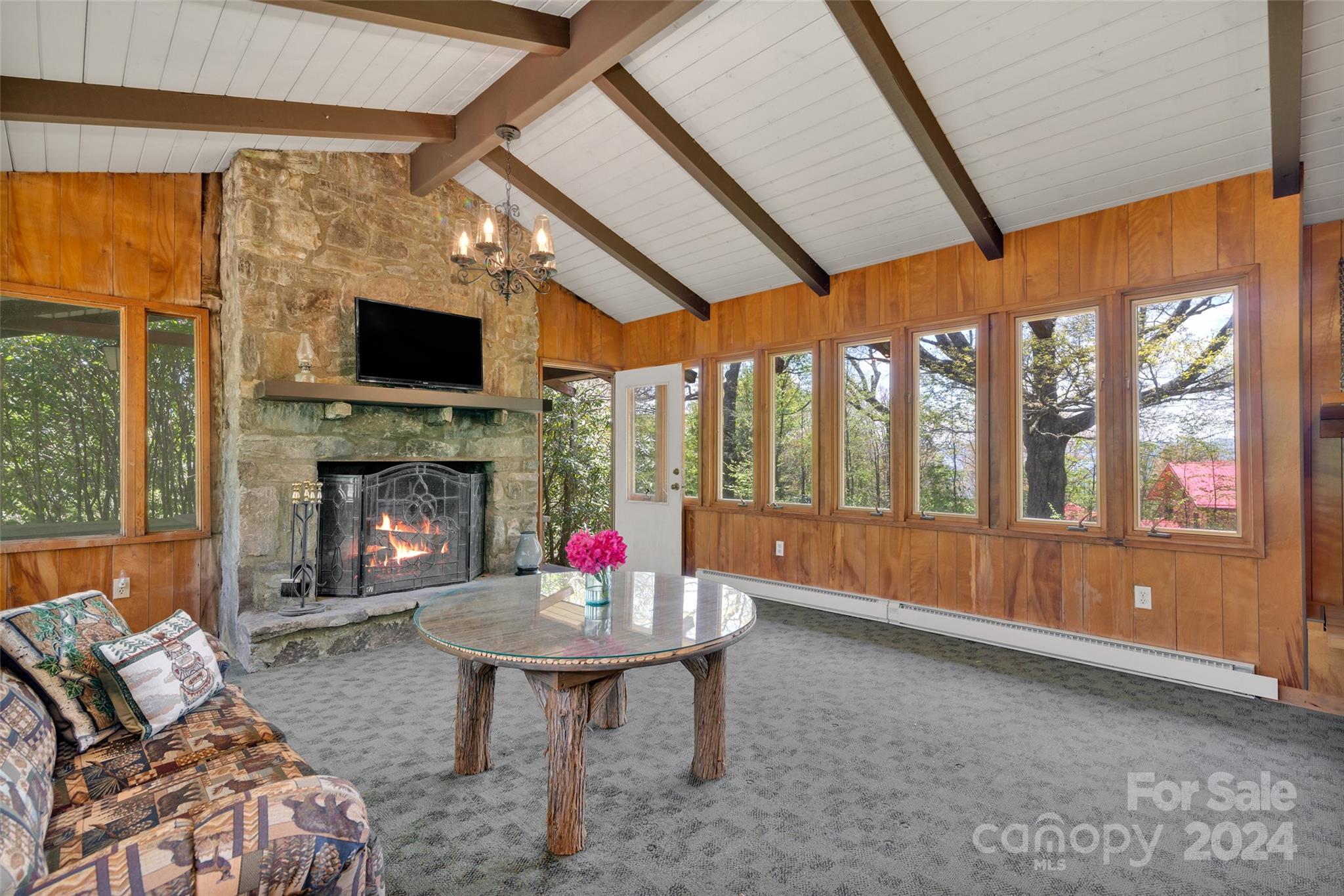 a living room with furniture a fireplace and a large window