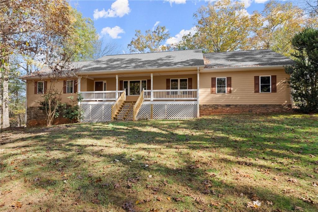 a front view of house with yard and trees in the background