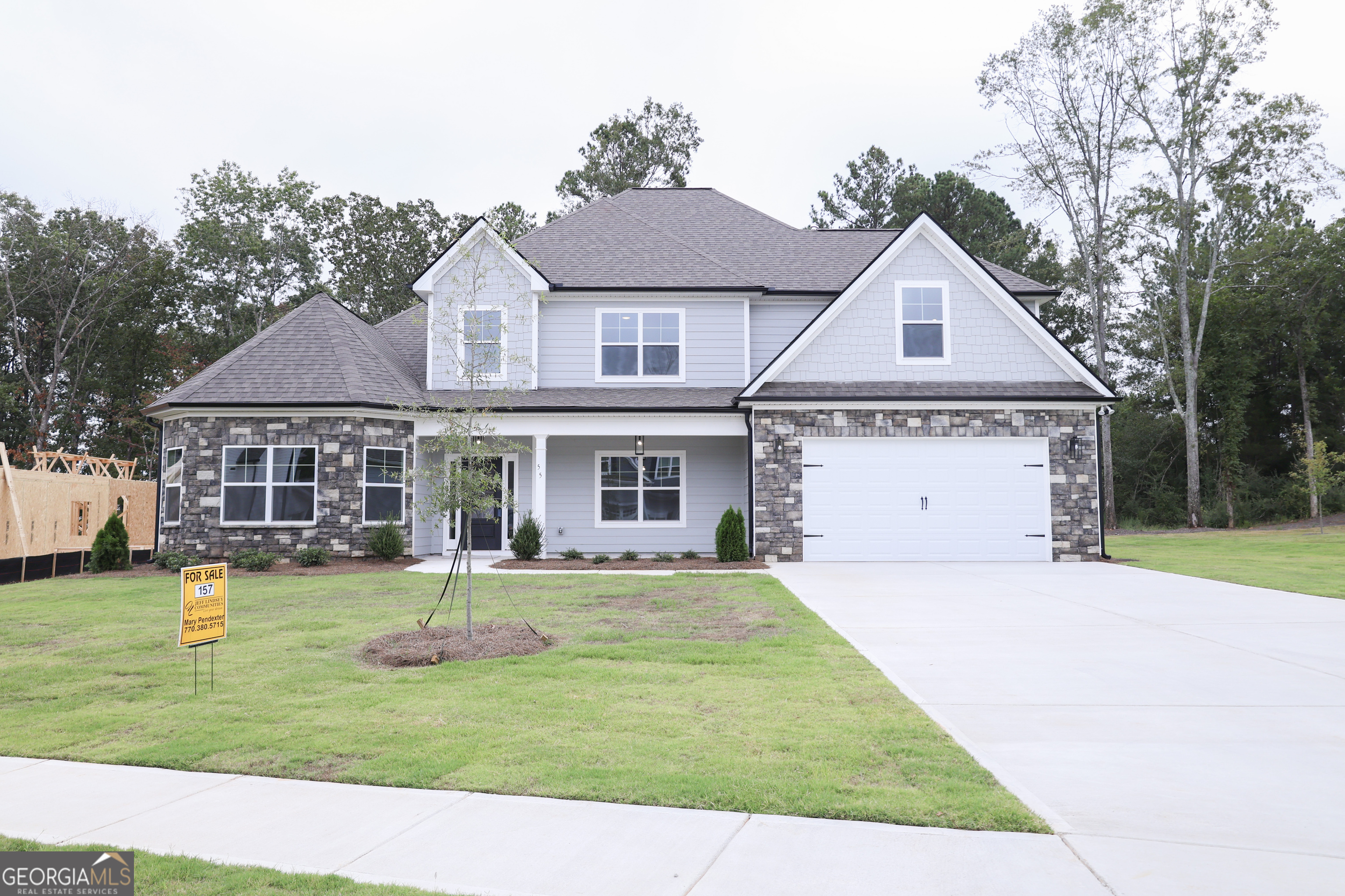 a front view of a house with a yard and trees