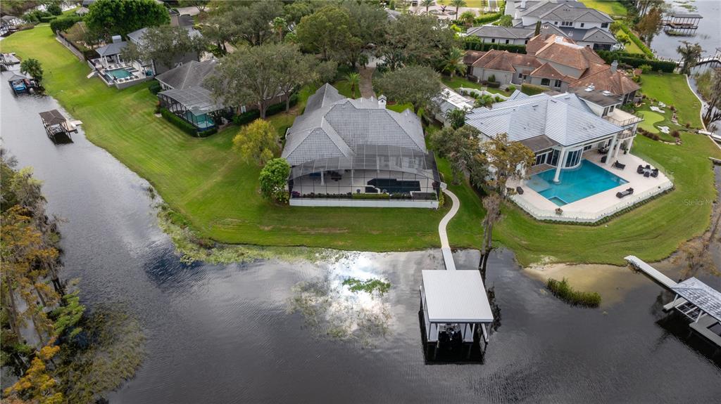 an aerial view of a house with swimming pool and outdoor seating