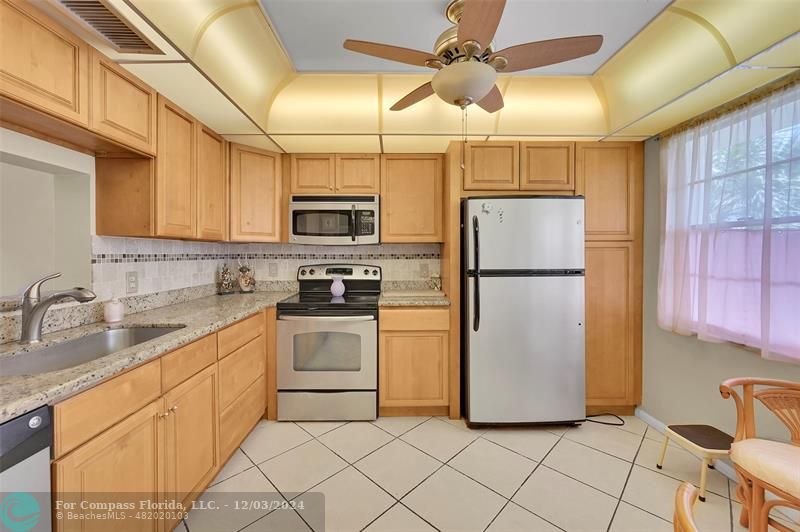 a kitchen with a refrigerator sink and cabinets