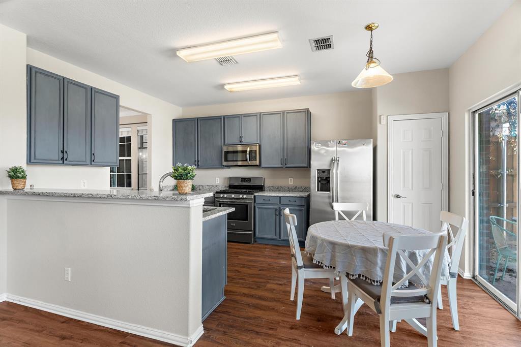 a kitchen with cabinets wooden floor and stainless steel appliances