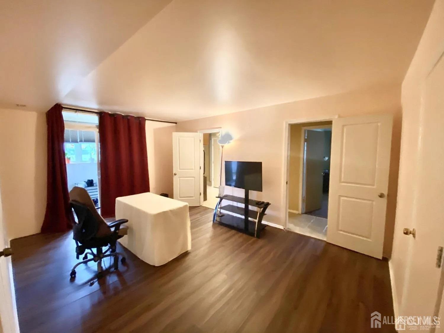 a living room with furniture a large window and wooden floor