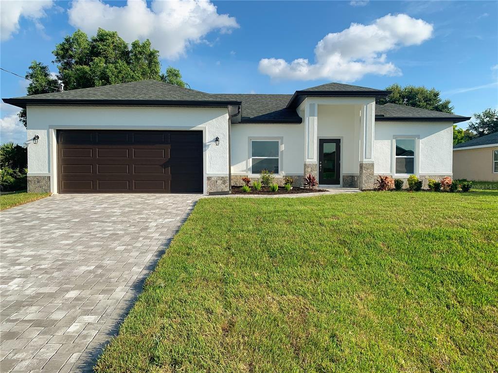 a front view of a house with a yard and garage