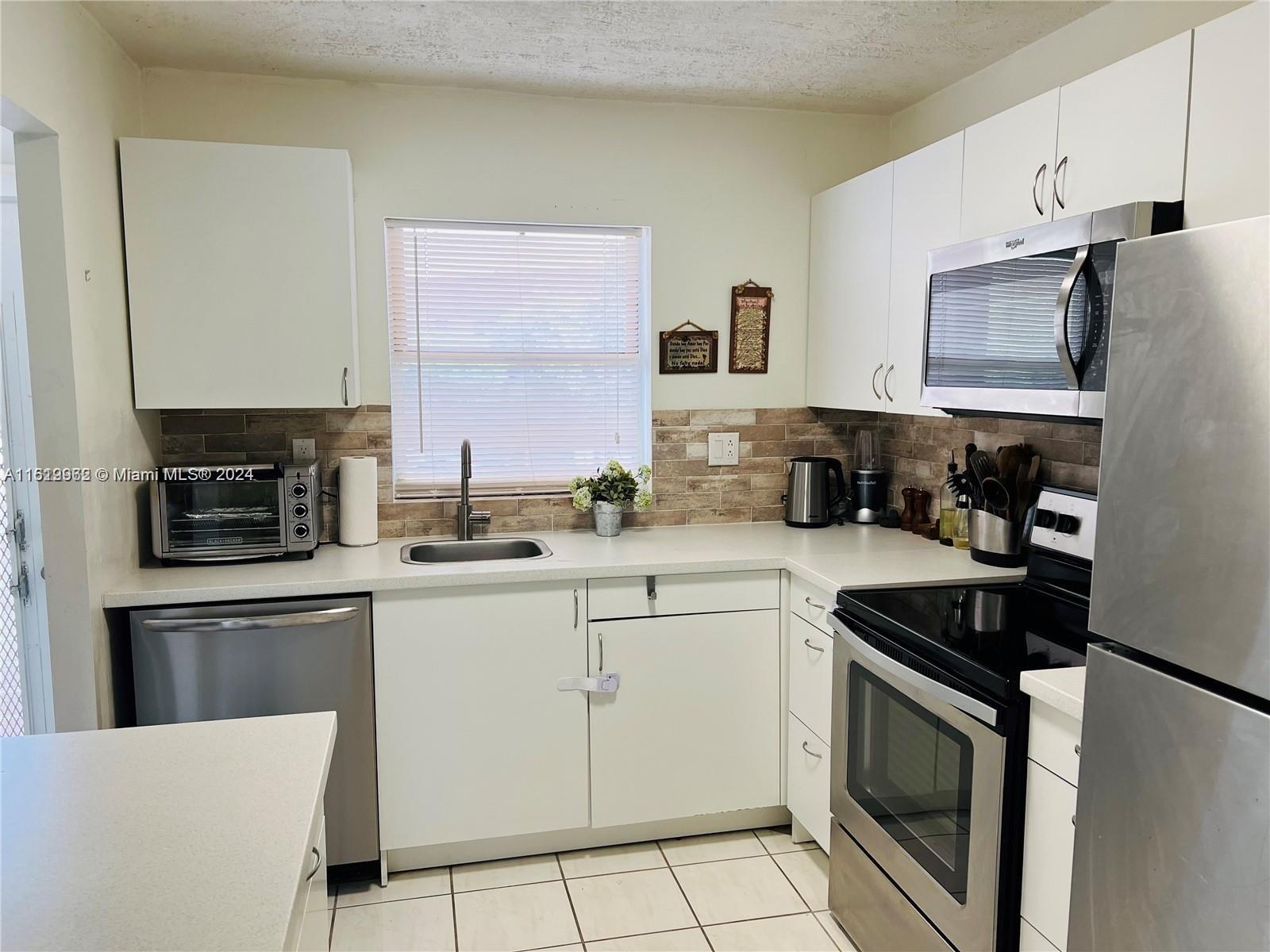 a kitchen with cabinets stainless steel appliances a sink and a counter top space