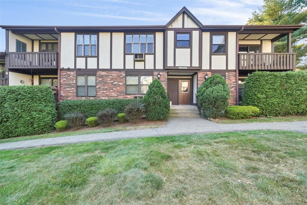 View of front of house featuring a front lawn and a balcony